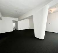 White walls and a dark carpet in commercial premises with a prominent pillar.