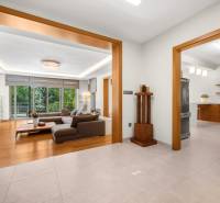 Living room and kitchen in a family house with a large window and wooden accessories.