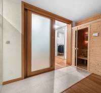 Interior of a family house with glass sliding doors and a wooden sauna.