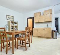 Kitchen unit, dining table, and bunk bed in a studio apartment.