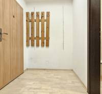 Hallway with built-in doors, wooden coat rack, and open entrance to the toilet.