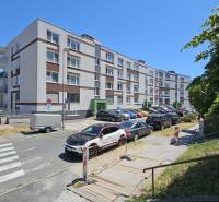 Apartment building on Jána Stanislava in Bratislava - Karlova Ves, parking lot and cars along the sidewalk.
