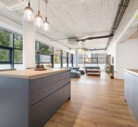 A kitchen with an island in a spacious 4-room apartment with wooden floors.