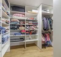 A wardrobe with a set of clothes and accessories in a 4-room apartment, light wooden floors.