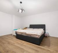 A bedroom with a gray bed, wooden floor, and children's toys in a 4-room apartment.