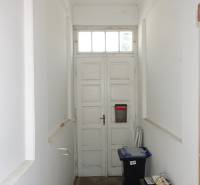 A hallway in a family house with old wooden doors and boxes on the floor.