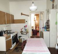 Kitchen in a family house with a dining table, stove, and cabinets.