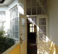 Entrance to the family house on Hviezdoslavova Street in Piešťany with glass doors and plants.