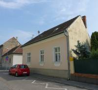A family house on Hviezdoslavova Street in Piešťany, with a red car parked by the road.