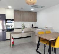 A kitchen in a 4-room apartment with a dining table and yellow chairs.