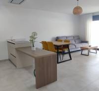 Interior of a 4-room apartment with a refrigerator, kitchen island, dining table, and sofa.