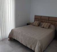 Bedroom in a 4-room apartment with a double bed and a window to the terrace.