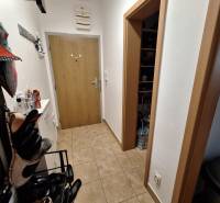A hallway with a shoe rack and a coat rack in a 3-room apartment, tiled floor.