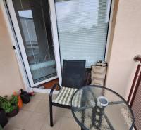 A small balcony with a round table and a chair in a 3-room apartment.