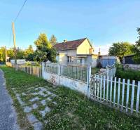 A family house in Kuzmice with a fence and a garden, next to a quiet street.