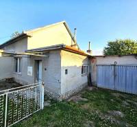A family house in Kuzmice with a garage, front garden, and a blue gate.
