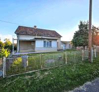 A family house in Kuzmice with a grassy yard and fencing on a quiet street.