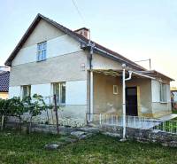 A family house in Kuzmice with a grassy garden and a gentle slope.