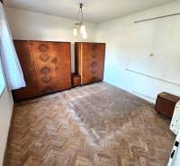 A room in a family house with a wooden floor and older furniture.