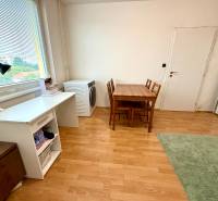 A table with chairs and a work corner in a studio apartment.