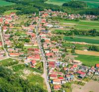A rural village surrounded by agricultural and forest lands and greenery.