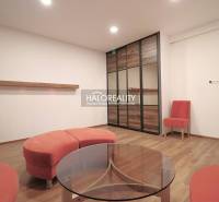 A room with a wooden floor, orange furniture, and a glass table, ideal for family living.