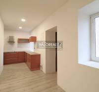 A kitchen with wooden cabinets and laminate flooring in a family house for sale.