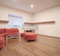 Living room of a family house with a red sofa set and wooden flooring.