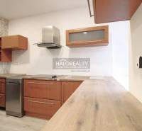 A kitchen with appliances, wooden cabinets, and a countertop, all in a family house.