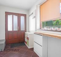 Entrance hall in a family house with wooden doors and a large window with a blind.
