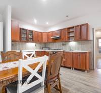 A kitchen in a family house, wooden kitchen unit, dining table and chairs.