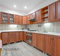 Kitchen in a family house with wooden cabinets and a stove.