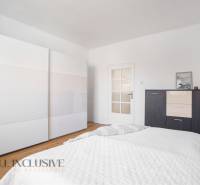 A bedroom in a family house with white cabinets and dark furniture.