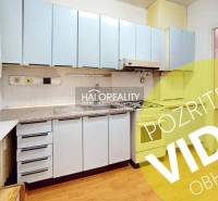 A kitchen in a 3-room apartment with blue cabinets, wooden flooring, and a gas stove.