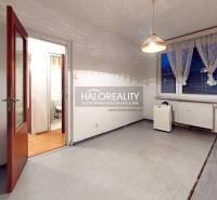 An empty room with wooden doors, a plastic window, and a curtain in a 3-room apartment.