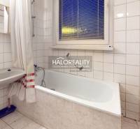 A bathroom with a bathtub and a sink, suitable for a 3-room apartment.