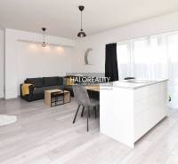 Living room in a family house with a kitchen island, sofa, and dining table.
