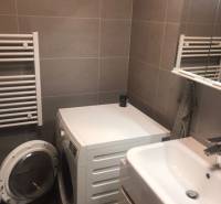 Bathroom with a washing machine and a sink in a 2-room apartment.