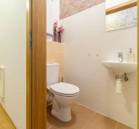 Toilet with a sink and mirror in a 3-room apartment, wooden door.