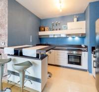 A kitchen in a 3-room apartment with a bar counter and modern equipment.