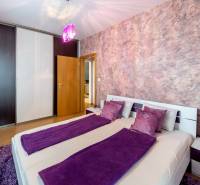 A bedroom in a 3-room apartment with purple decorations and a built-in wardrobe.