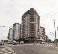 Intersection on Kaštieľska Street in Bratislava, Ružinov, with a building and traffic.