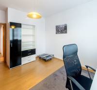 A study in a 3-room apartment with a desk, a black wardrobe, and an office chair.