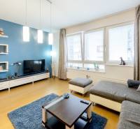 A stylish living room with a comfortable sofa and a television in a three-room apartment.