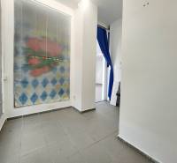Interior of a commercial space with a tiled floor and a blue curtain.
