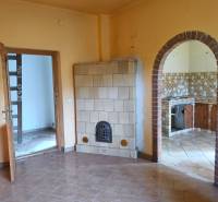 Family house with a tiled stove and an arched entrance to the kitchen, tiled flooring.