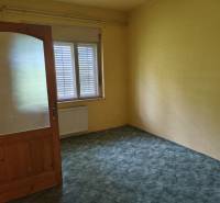A room in a family house with yellow walls and wooden doors, suitable for rent.