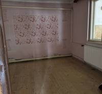 A room with a wooden floor, floral wallpaper, and a window, Family house.