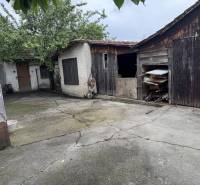 The courtyard of a family house in Dobrohošť with wooden shelters and a concrete surface.