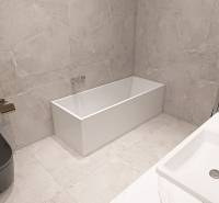 The bathroom in the 3-room apartment includes a bathtub, a sink, and a toilet with gray tiles.